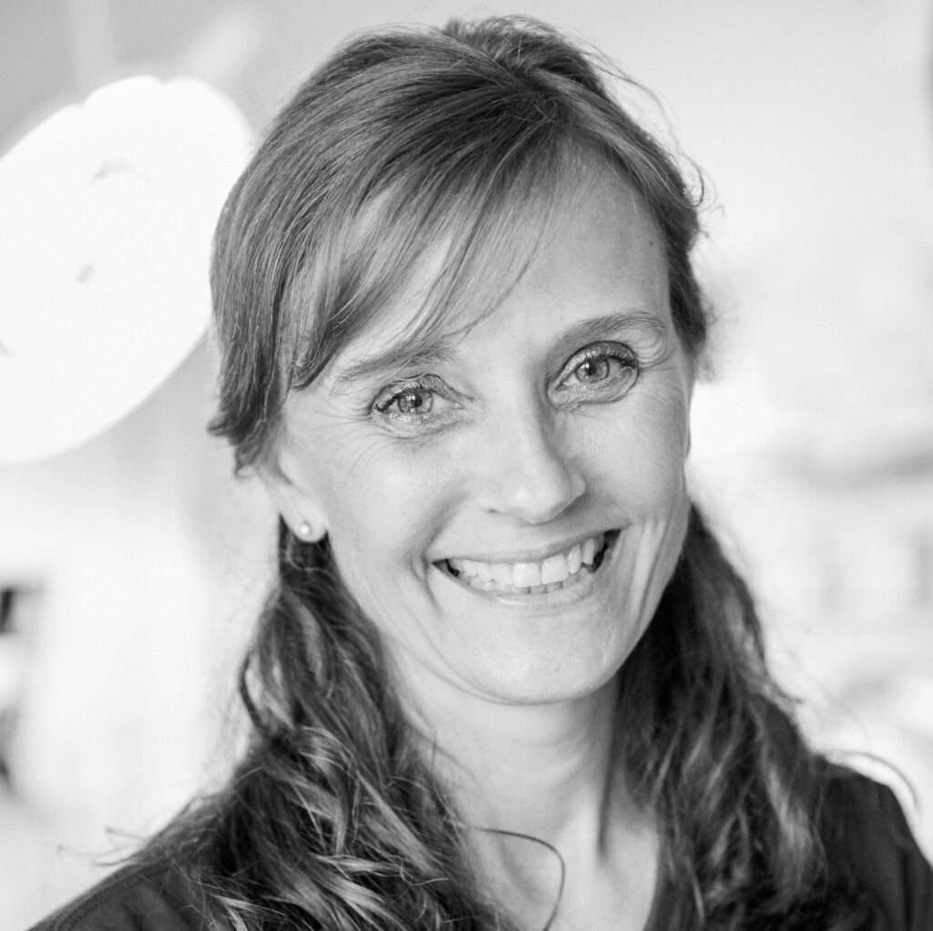 Smiling woman in black and white portrait.