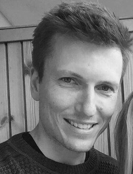 Smiling person in a sweater indoors.